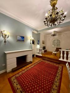 a living room with a fireplace and a red rug at Ritz hotel in Alexandria