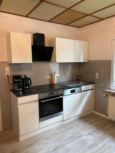 a kitchen with white cabinets and a stove top oven at Ferienhaus in der Altmark in Kakerbeck
