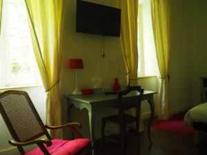 a room with a desk and a table with a chair at L'affable Les cammazes in Les Cammazes