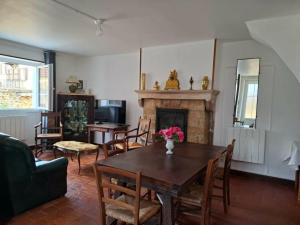 a living room with a table and a fireplace at Le refuge des Champeaux in Domecy-sur-le-Vault