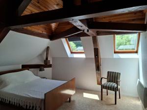 a bedroom with a bed and a chair at Le refuge des Champeaux in Domecy-sur-le-Vault