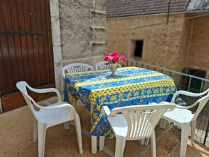 a table with chairs and a vase with flowers on it at Le refuge des Champeaux in Domecy-sur-le-Vault