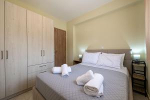 a bedroom with a bed with towels on it at Anima Horizon-Petra Apartment in Elaiófiton