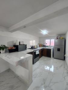 a large white kitchen with a refrigerator and a stove at Trajineras xochimilco in Mexico City