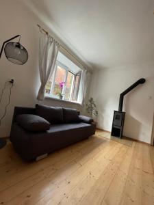 a living room with a black couch and a window at Leon in Lomnice nad Lužnicí