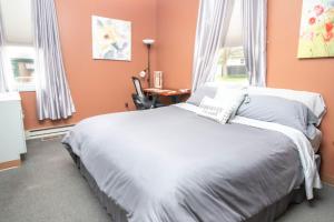 a bedroom with a bed with orange walls and a window at Foothills Lodge & Cafe in Malone