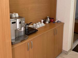 a counter with a coffee maker and coffee cups at Hostel JAPI in Aleksinac