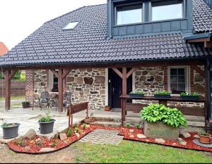 a stone house with a porch with a bench and plants at Apartmán Kameňák in Stožec
