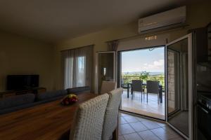 a living room with a table and chairs and a dining room at Anima Horizon-Petra Apartment in Elaiófiton