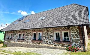a stone house with windows and a roof at Apartmán Kameňák in Stožec