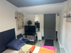 a bedroom with a bed and a tv and a door at Venise chambre accès privé in Castres