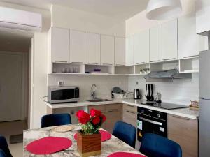 a kitchen with a table with a vase of flowers on it at Condo in Marassi Marina in El Alamein