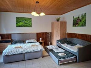 a bedroom with two beds and a table at Apartmán Kameňák in Stožec