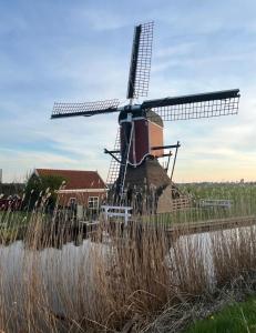 a windmill in the middle of a field at Velthorst 6 in Warmond +4 photos