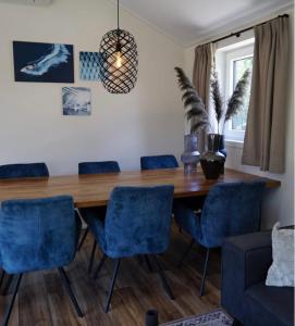 a dining room with a wooden table and blue chairs at Velthorst 6 in Warmond