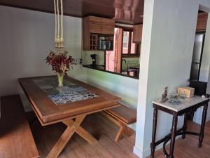 a dining room table with a vase of flowers on it at Privê Monte Serrat, Chalé 18 in Gravatá