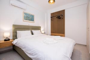a bedroom with a large white bed with white sheets at Green Almond's Comfort Apartment in Orfánion +16 photos