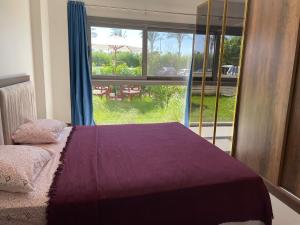 a bedroom with a bed and a large window at Condo in Marassi Marina in El Alamein +13 photos