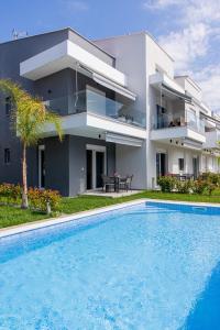a house with a swimming pool in front of a house at Green Almond's Comfort Apartment in Orfánion