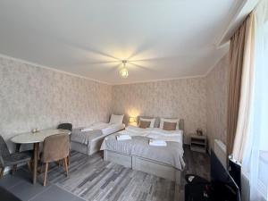 a hotel room with two beds and a table at Apartments Gio-Nika in Kazbegi