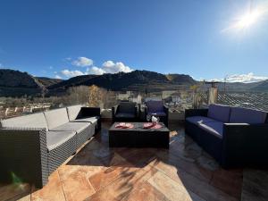 a patio with couches and a table and mountains at El Rincón de María II in Torrecilla en Cameros