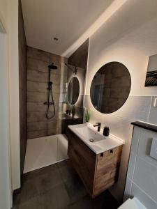 a bathroom with a sink and a shower at Ferienwohnung III in Eisenhüttenstadt +6 photos