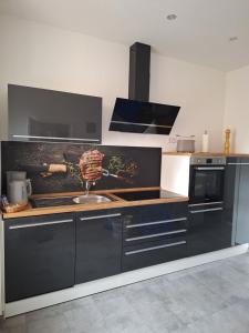 a kitchen with a sink and a stove top oven at Ferienwohnung III in Eisenhüttenstadt