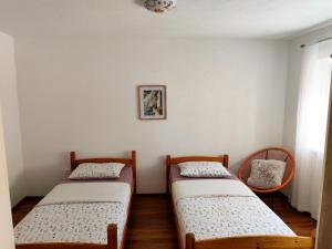 two twin beds in a room with a window at Apartman Dream in Livno