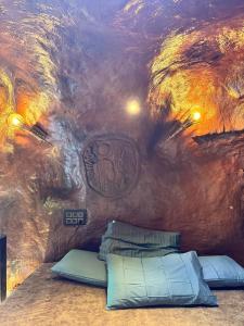 a room with a painting on the ceiling with two beds at Rai’s Coorg Cave House in Madikeri
