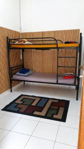 a bunk bed in a room with a rug at Medan Dazhong Backpacker's Hostel in Medan