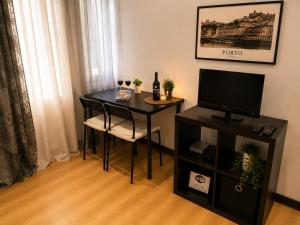 a room with a table with a television and a chair at Espaço-Zero Downtown Porto in Porto