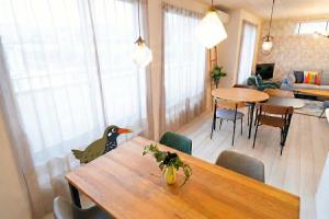 a living room with a dining room table with a bird on it at OKINAWA BEACH HOUSE Golden Drop S in Yaka