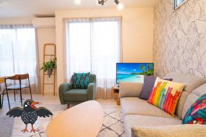 a living room with a couch and a table at OKINAWA BEACH HOUSE Golden Drop S in Yaka