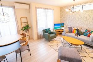 a living room with a couch and a table at OKINAWA BEACH HOUSE Golden Drop S in Yaka