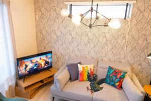 a living room with a couch and a television at OKINAWA BEACH HOUSE Golden Drop S in Yaka