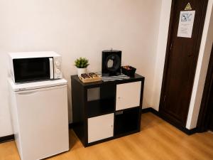 a microwave sitting on top of a refrigerator at Espaço-Zero Downtown Porto in Porto