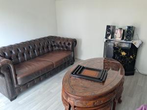 a living room with a brown leather couch and a table at La Châtelaine in Lombez +17 photos