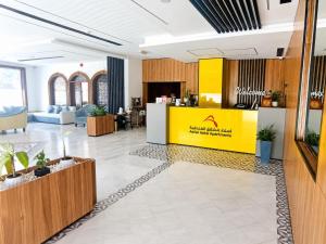 a lobby of a building with a yellow wall at Asfar Hotel Apartments أسفار للشقق الفندقية in Muscat