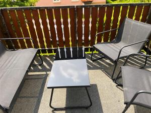 two chairs and a bench on a balcony at Monteur-Ferienwohnung Julianna in Bad Staffelstein in Bad Staffelstein +1 photo