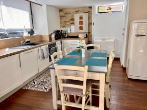 a kitchen with a table and chairs in a kitchen at Le Petit Vigneau in Ménil