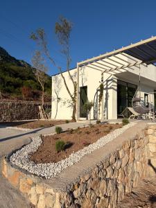 a stone retaining wall in front of a house at Green House in Perazića Do