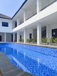 a swimming pool in front of a building at Aisyi Tower Klaten in Klaten
