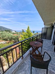 a balcony with a table and chairs and a view at Pension Assos in Koinyra