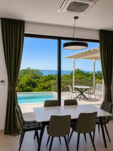 a dining room with a table and chairs and a pool at Green House in Perazića Do