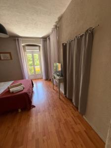 sypialnia z łóżkiem, stołem i oknem w obiekcie Appartement Corte w mieście Corte