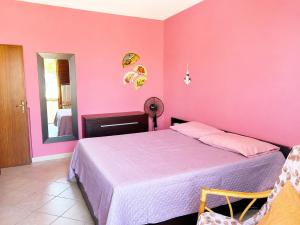 a bedroom with pink walls and a bed in a room at Casa Guia a Marina di Cecina con parcheggio privato in Marina di Cecina