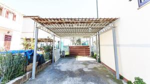 an entrance to a building with a wooden pergola at Casa Guia a Marina di Cecina con parcheggio privato in Marina di Cecina