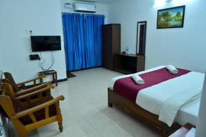 a bedroom with a bed and a television in it at Sree Durga Veerabhoomi Resort in Kushālnagar