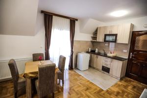 a kitchen and dining room with a table and chairs at Apartmani Jasika Zlatar in Nova Varoš