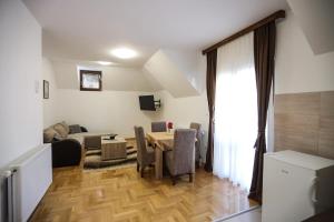 a living room with a table and a couch at Apartmani Jasika Zlatar in Nova Varoš